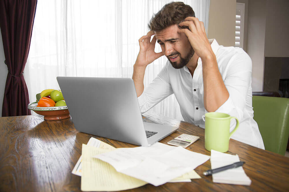 a stressed man on a laptop